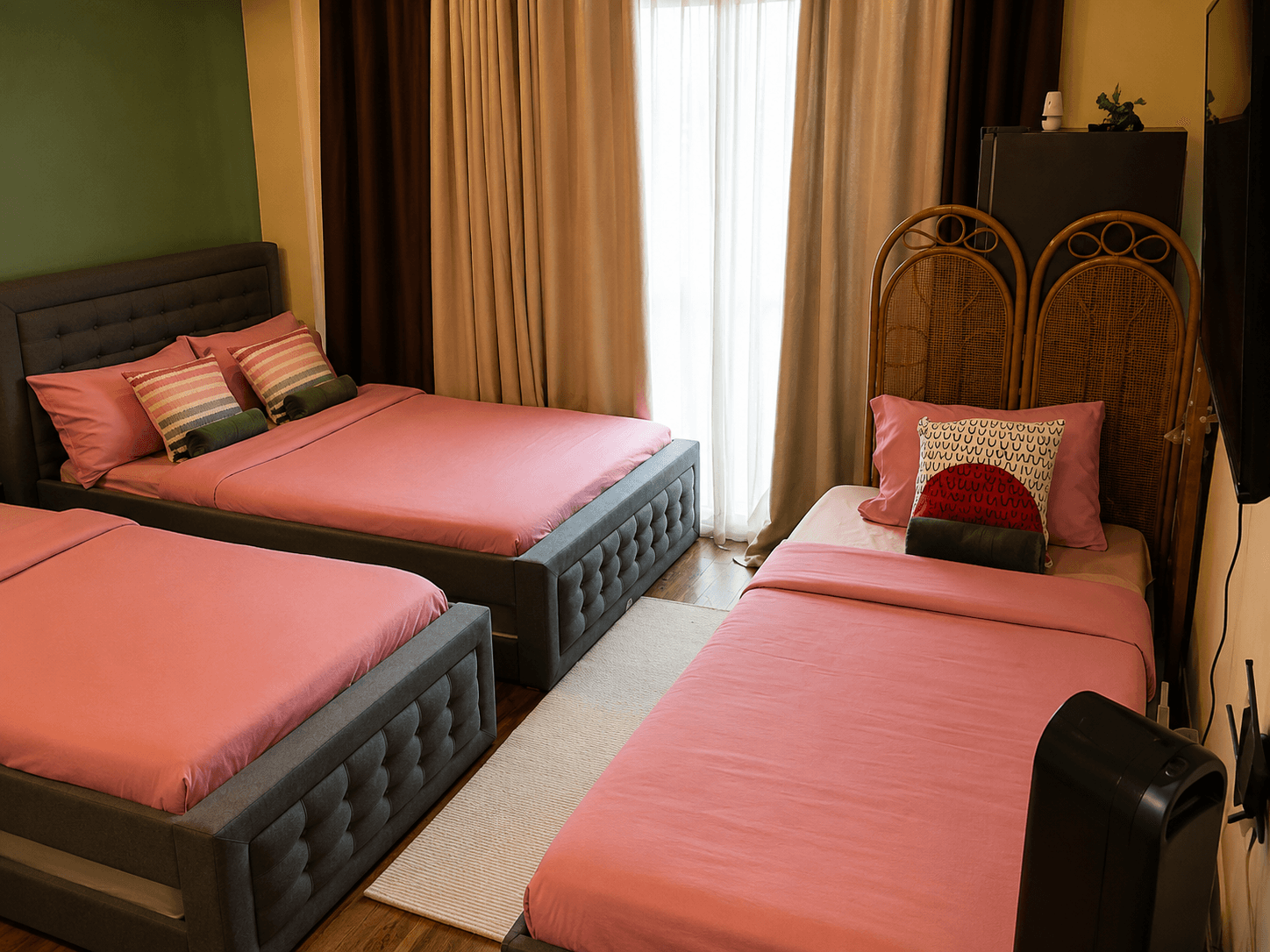 Spacious bedroom with queen and twin beds and green accent wall