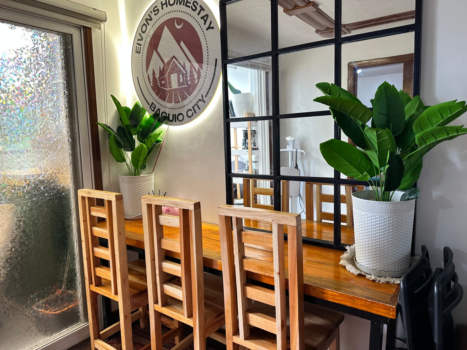 Dining area with wood table and Eivon's Homestay signage